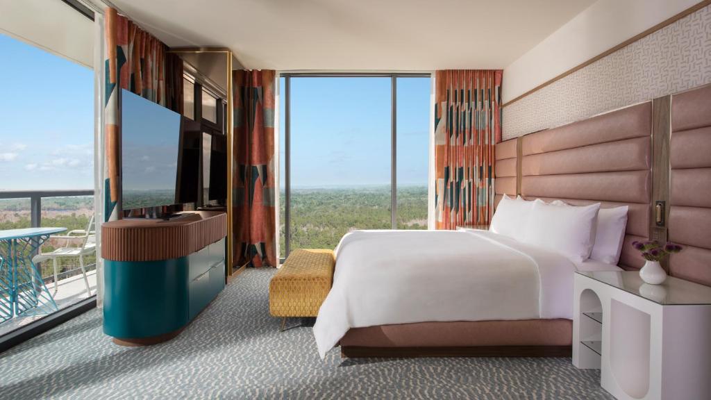 オーランドにあるLake Nona Wave Hotelのベッドとバルコニーがあるホテルの部屋