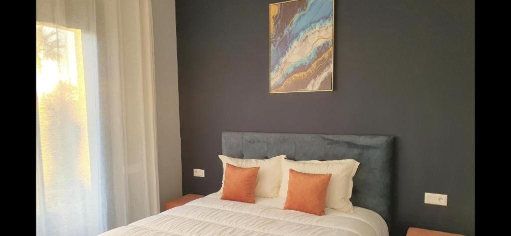 een slaapkamer met een bed met oranje en witte kussens bij VILLA HANANE in Riaïna