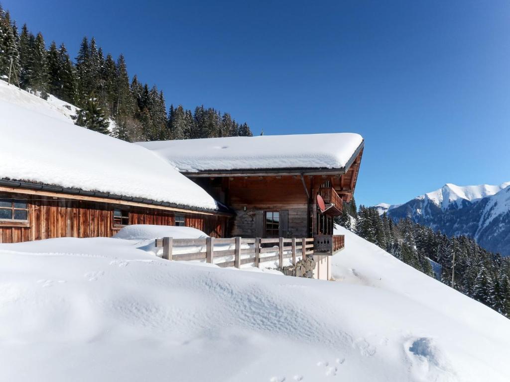 una cabaña cubierta de nieve en las montañas en Chalet Naulaz by Interhome, en Val dʼIlliez