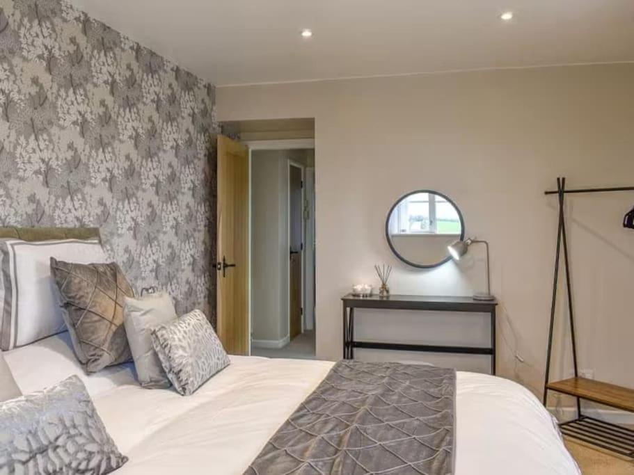 a bedroom with a large bed and a mirror at Cremlyn Lodge in Beaumaris