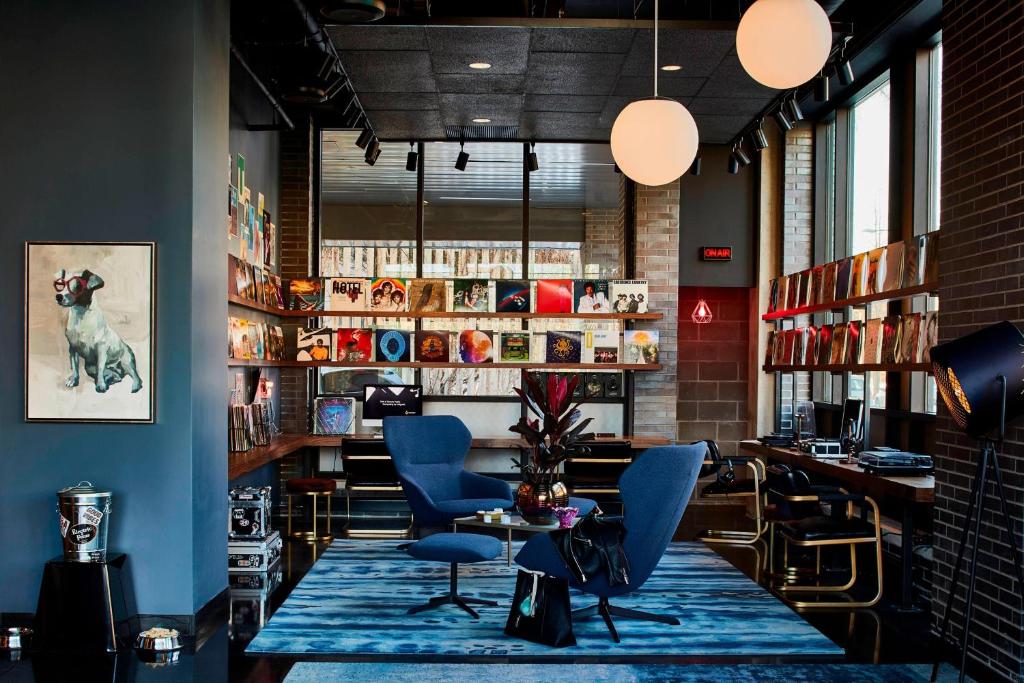 een bar met blauwe stoelen en een tafel in een kamer bij MOXY Minneapolis Uptown in Minneapolis