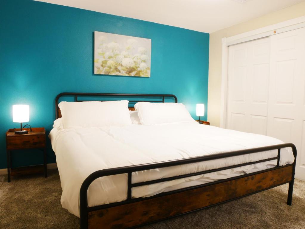 - une chambre avec un grand lit et un mur bleu dans l'établissement Private Basement, Bath, Living Area In Morrison, à Morrison