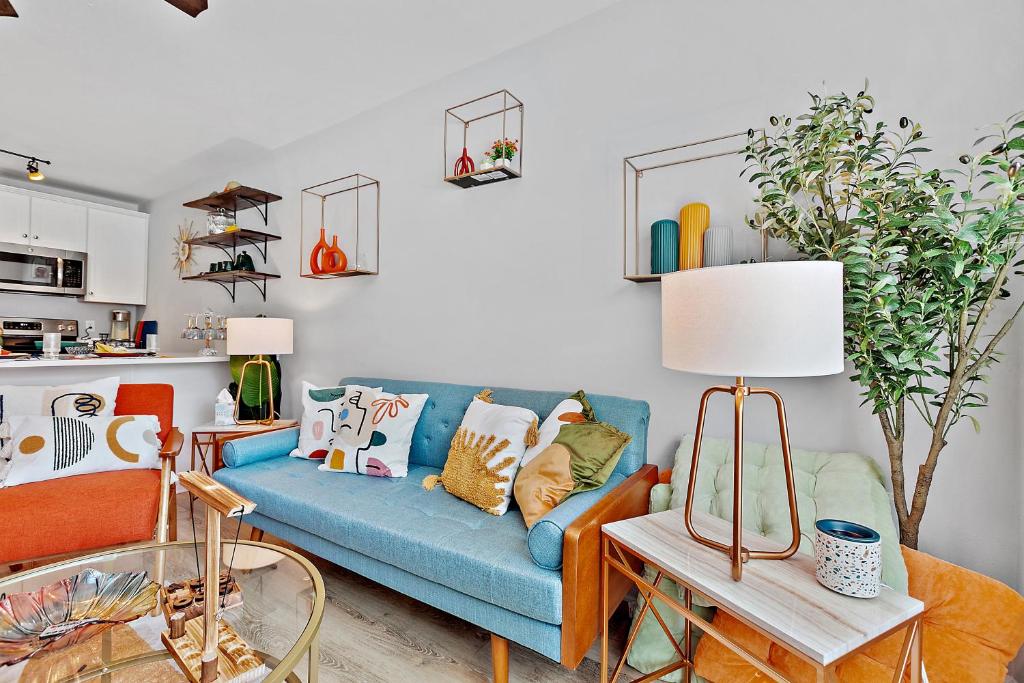 uma sala de estar com um sofá azul com almofadas em Beautiful 3-suite home w/ patio dining, big yard em Tallahassee