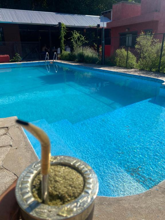 una piscina con una manguera saliendo de ella en Casita de las sierras en Córdoba