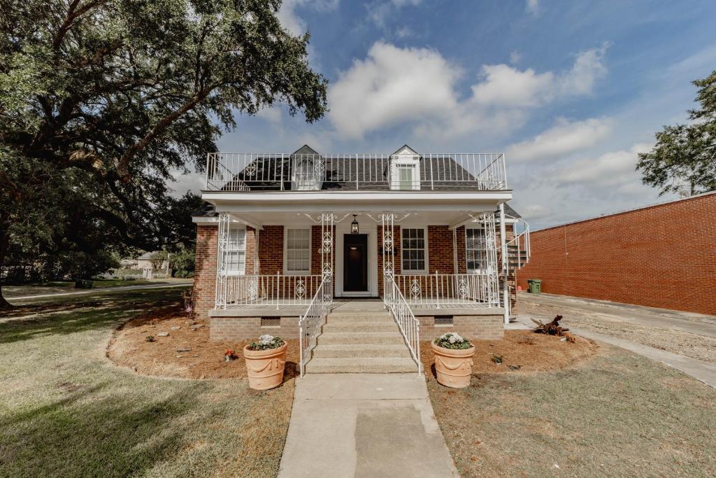 a brick house with a porch and stairs in front at Comfortable King Suite Zen Space in Hattiesburg