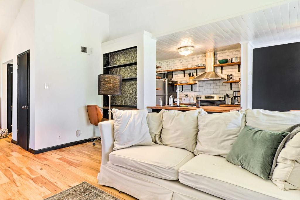 a living room with a white couch and a kitchen at Austin Condo with Patio - 4 Mi to Downtown! in Austin