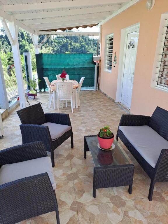 a patio with couches and a table on a patio at Maison d&#39;une chambre avec piscine partagee terrasse amenagee et wifi a Petit Bourg in Petit-Bourg