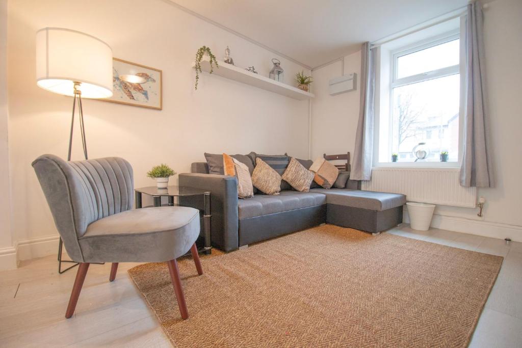 a living room with a couch and a chair at St Peters Townhouse by Property Promise in Cardiff