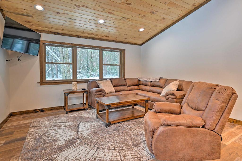 a living room with a couch and a table at Vacation Rental Cabin Near Lake Arbutus! in Hatfield