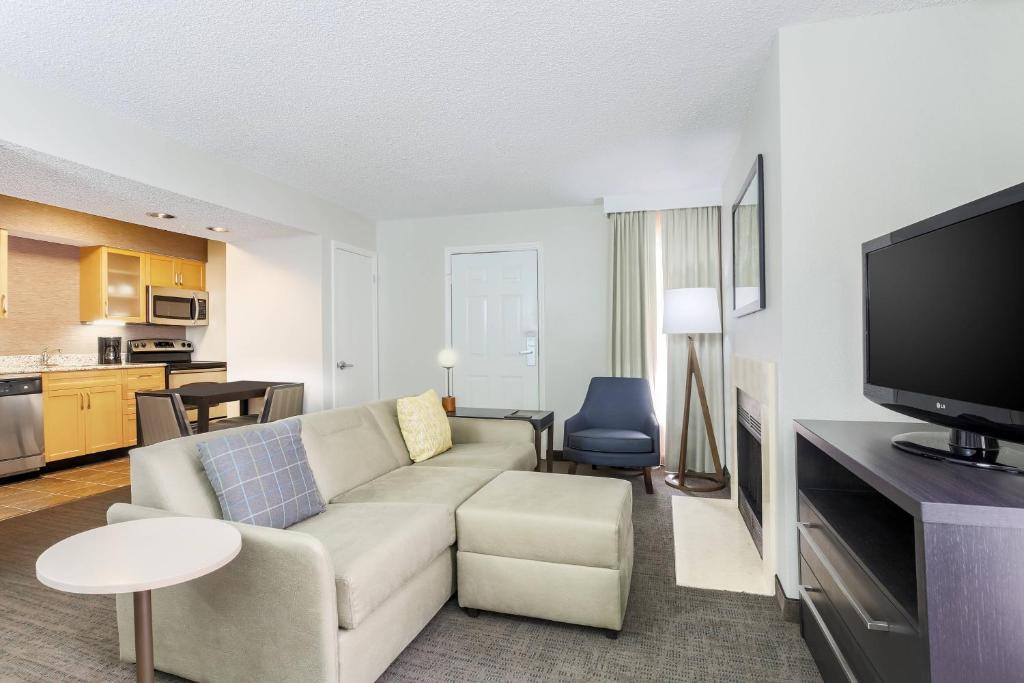 a living room with a couch and a flat screen tv at Residence Inn Boca Raton in Boca Raton