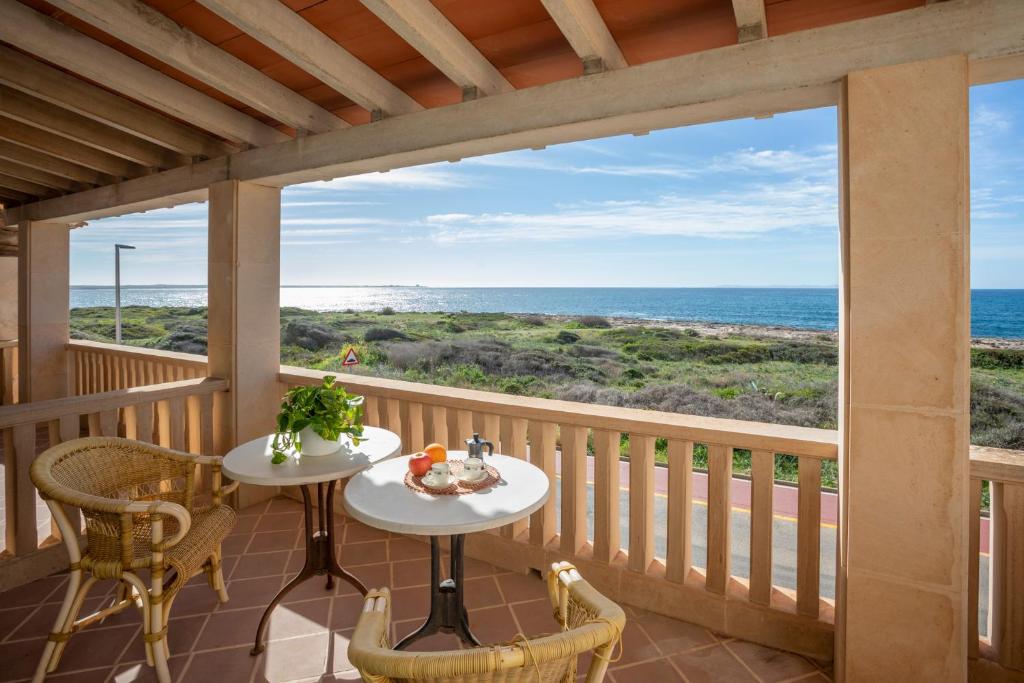 a porch with two tables and chairs and a view of the ocean at Sa Rapita see view - Grupo Berna in Sa Ràpita