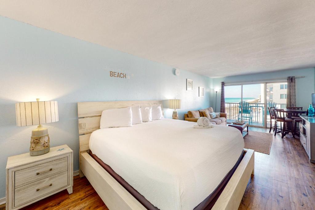 a bedroom with a large bed and a living room at Islander W 605 in Fort Walton Beach