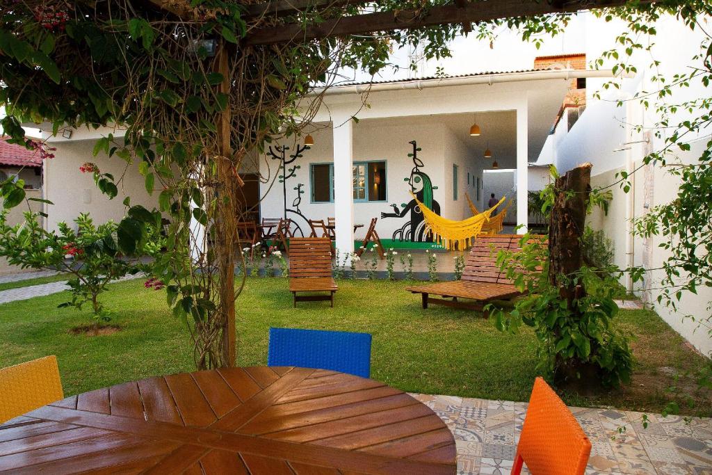 einen Hinterhof mit einem Holztisch und Stühlen in der Unterkunft Casa Azul Maragogi in Maragogi