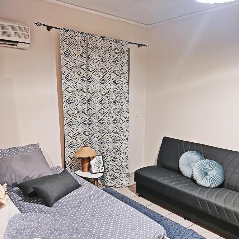 a living room with a couch and a window at Sweet studio in Pyrgos city near Olympia in Pýrgos