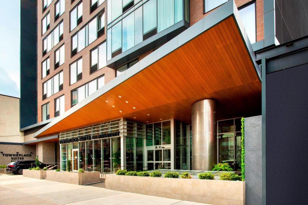 un grand bâtiment avec un grand bâtiment en verre dans l'établissement TownePlace Suites by Marriott New York Long Island City, à Queens