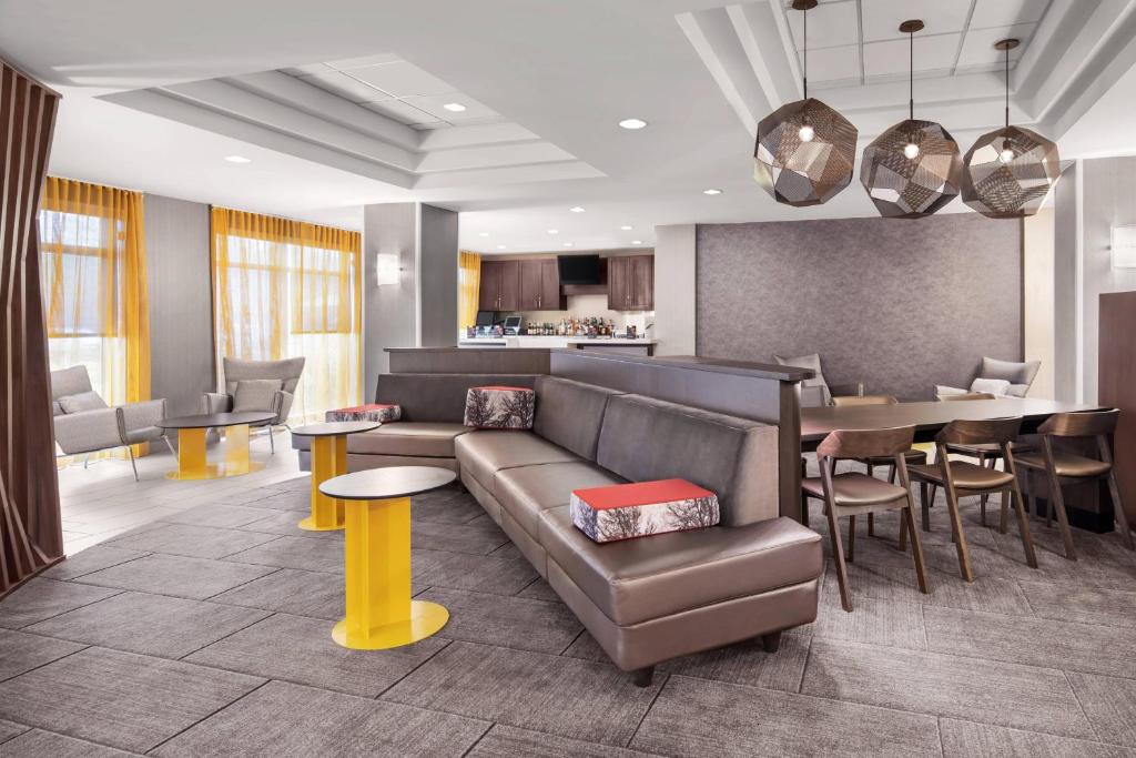 SpringHill Suites Houston Hobby Airport في هيوستن: غرفة معيشة مع أريكة وطاولة