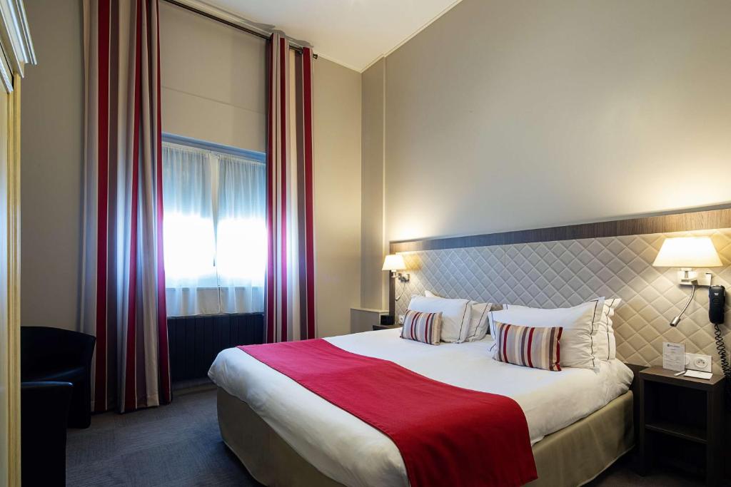 a hotel room with a large bed with a red blanket at Best Western Central Hotel in Tours