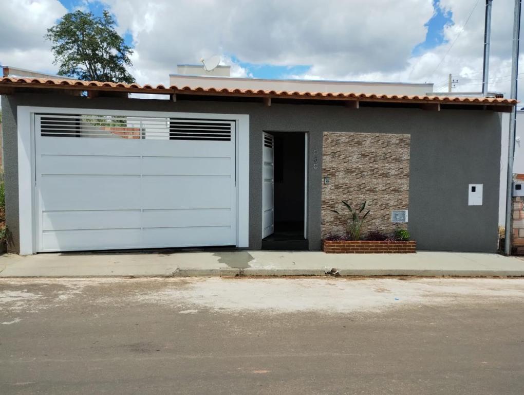 uma porta de garagem branca numa casa pequena em Casa Serra da canastra em São João Batista do Glória