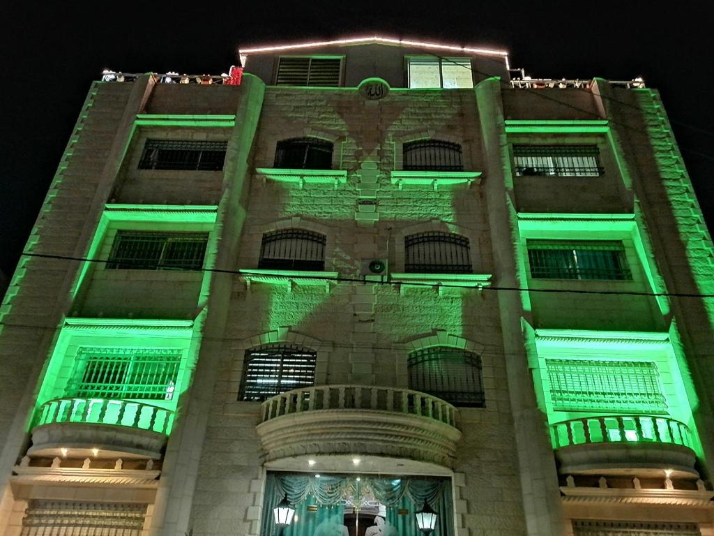 un edificio con luci verdi sopra di esso di Yaso Roof & Apartments ad Amman
