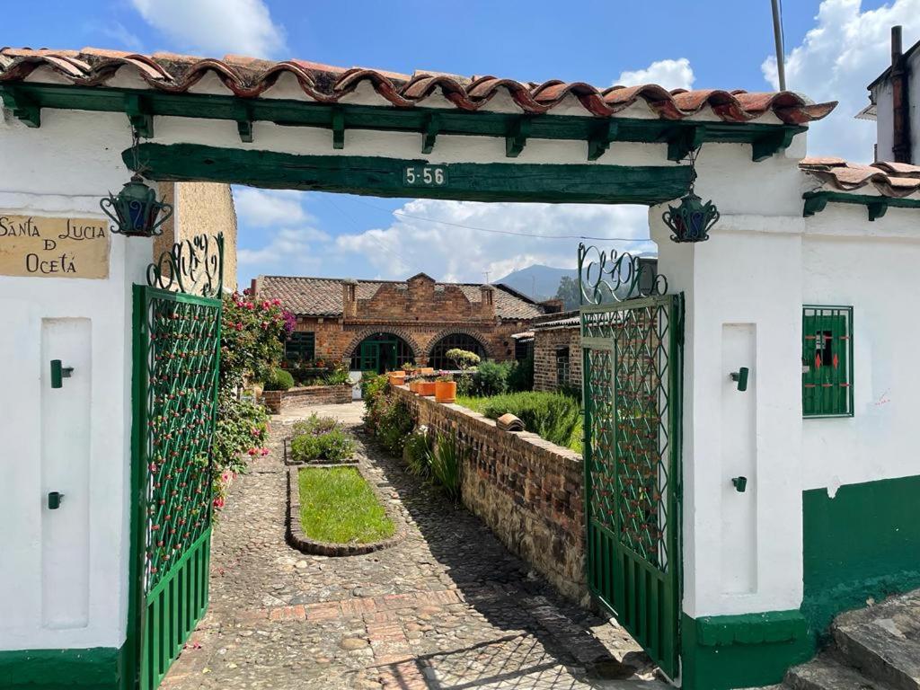 einen Eingang zu einem Haus mit grünem Tor in der Unterkunft Habitación Privada en Mongui in Monguí