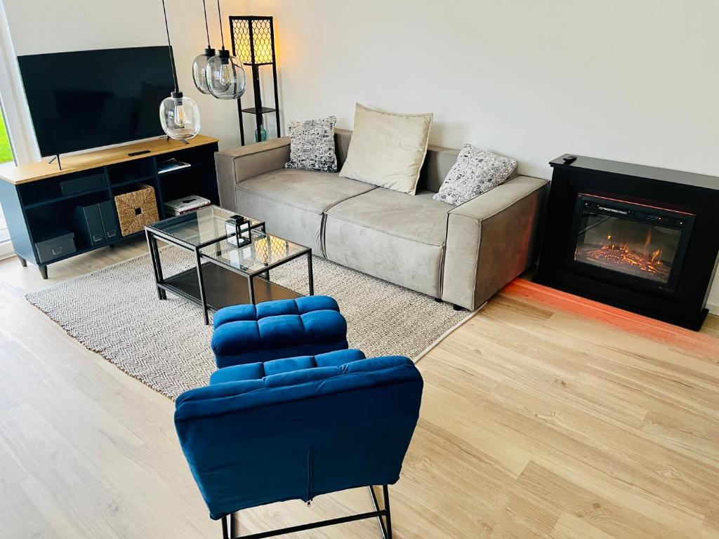 a living room with a couch and a fireplace at MyBLEISURE Premium Apartment mit Küche und Netflix nahe Heidelberg I SAP, MLP, Unternehmen im Rhein-Neckar-Kreis in Rauenberg