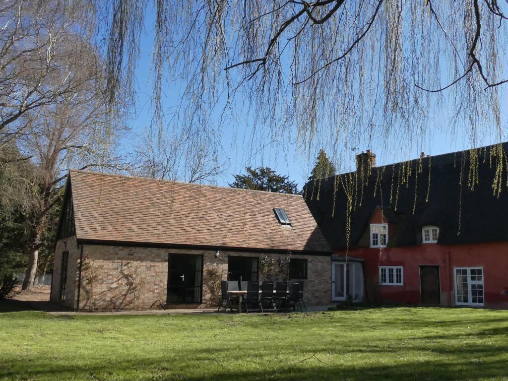 an old brick house with a large grass yard at West Farm Cottage in Godmanchester