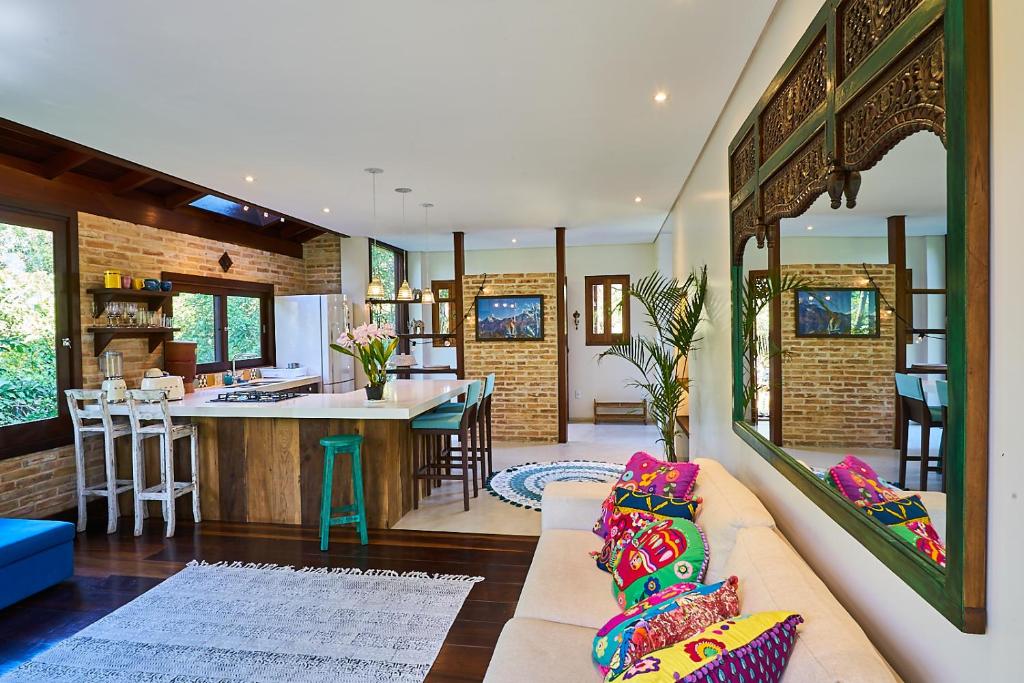 Casa Bali Ibira في إيمبيتوبا: غرفة معيشة مع أريكة ومطبخ