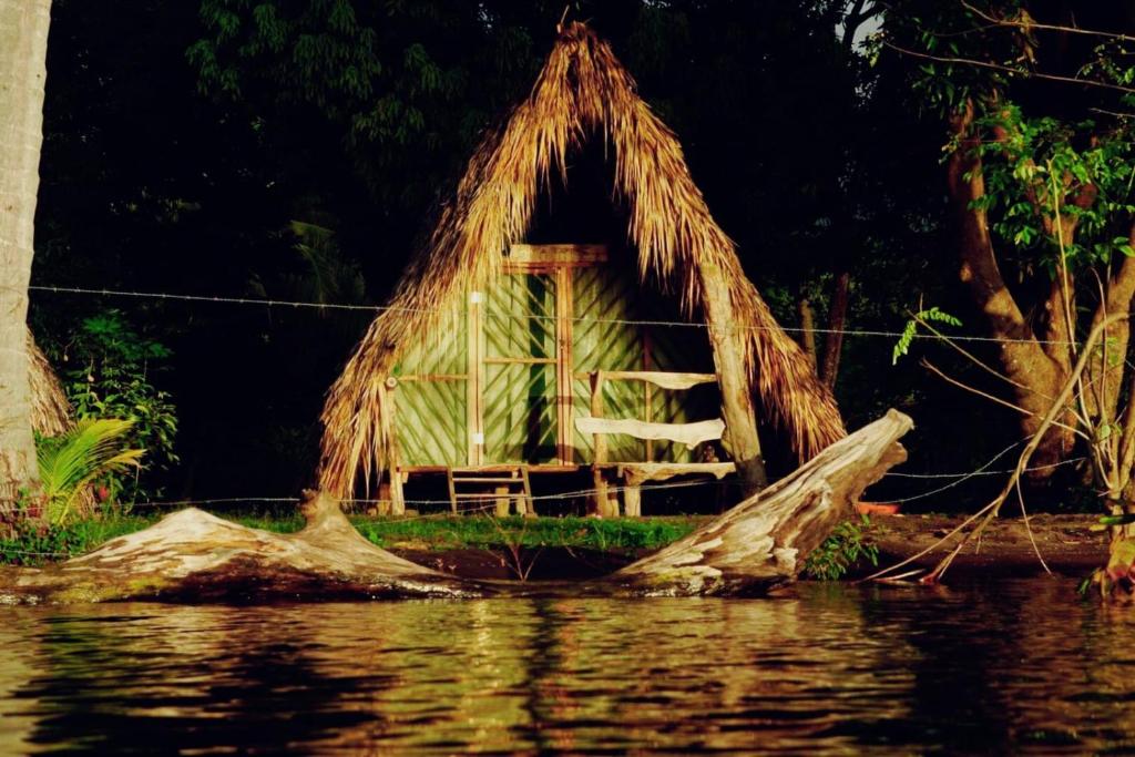 a shack on the shore of a body of water at La Sirenita - Ometepe in Altagracia