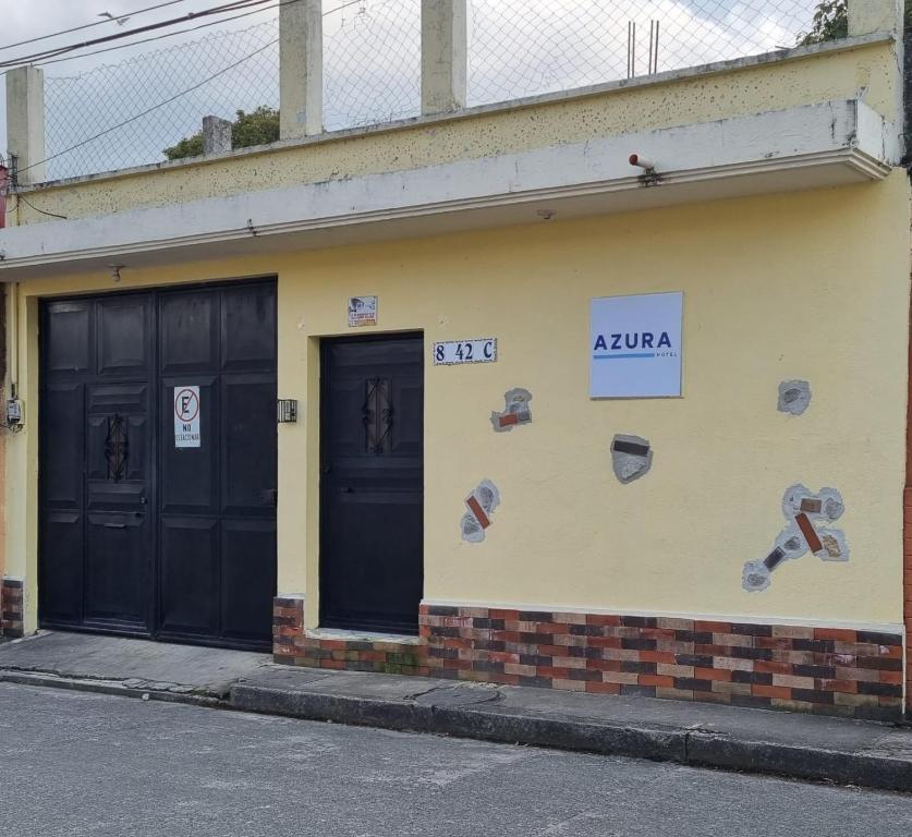 a building with two doors and shoes on the side at AZURA HOTEL BOUTIQUE in Cobán
