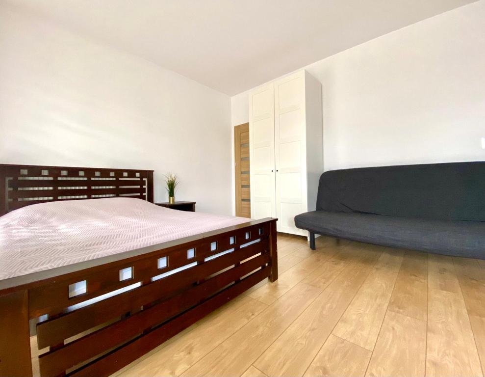 a bedroom with a bed and a couch at K22 Komputerowa Warsaw Apartments in Warsaw
