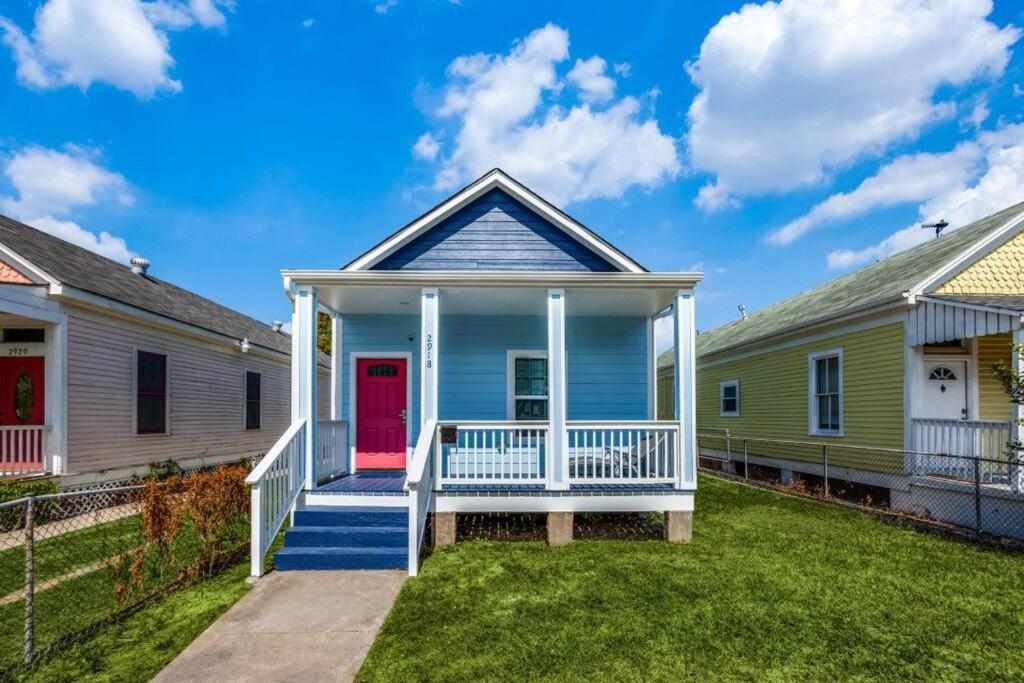 una casa azul con una puerta roja y un patio en Cozy brand new beach house - 2 mins to the beach en Galveston