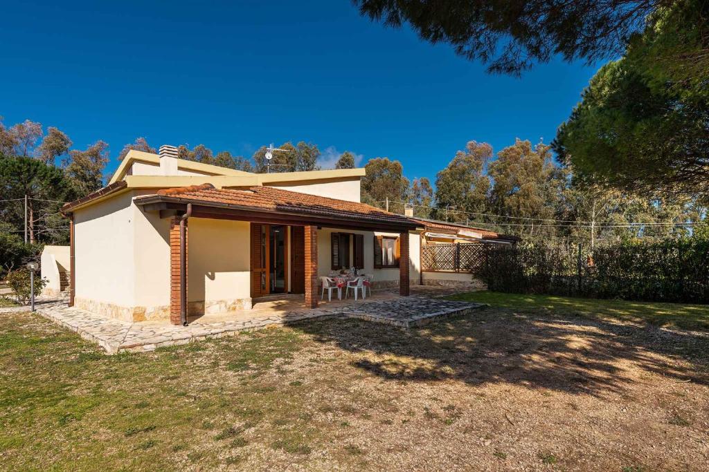 een klein wit huis met een patio in een tuin bij Holiday home in Alghero 43629 in Alghero