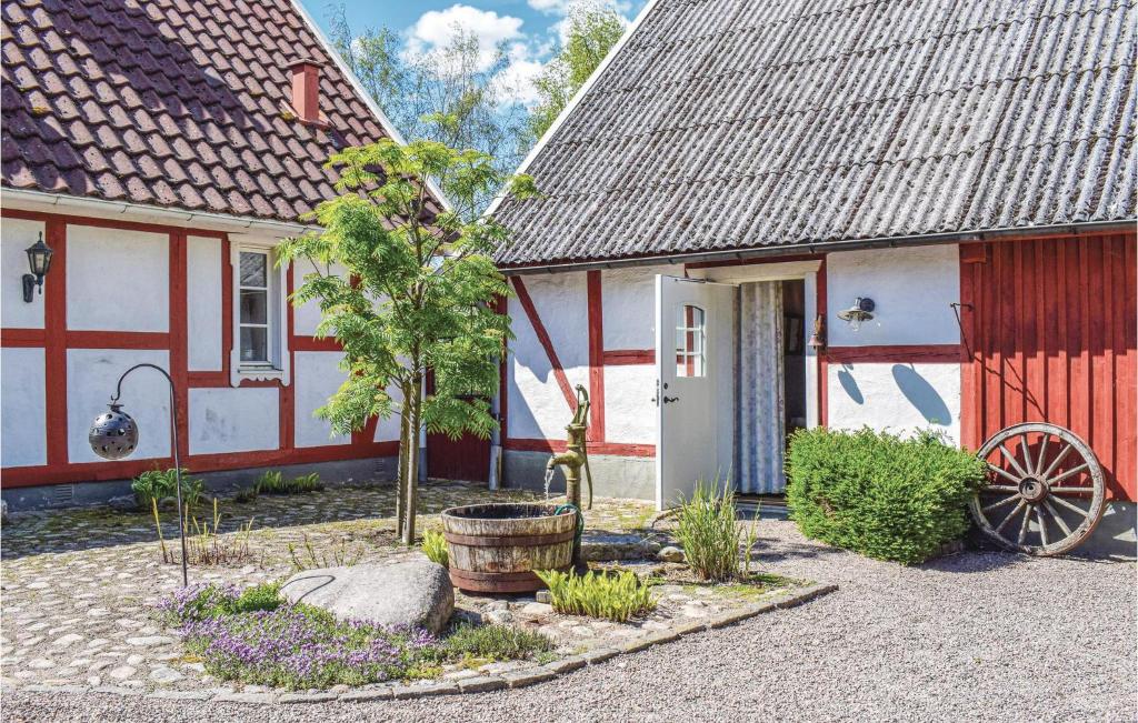 a house with a red door and a barn at Beautiful Home In Munka-ljungby With Wifi in Munka-Ljungby