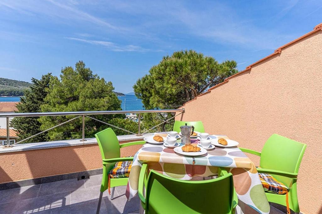 a table and chairs on a balcony with a view at Apartments by the sea Cres - 8095 in Cres