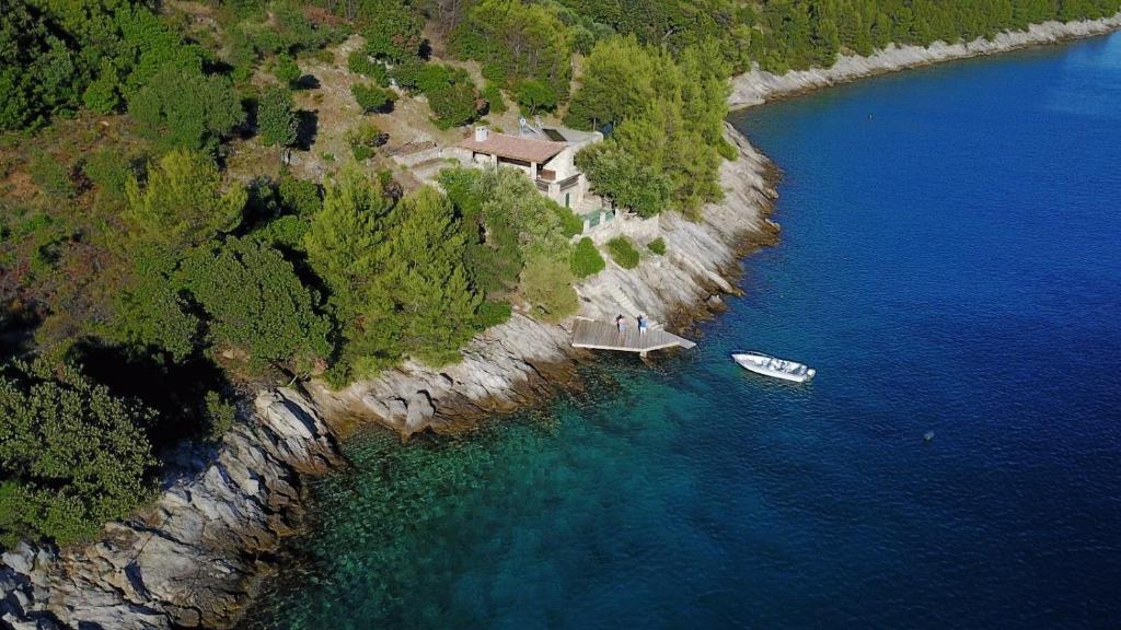 an aerial view of a house and a boat in the water at Secluded fisherman's cottage Cove Vela Studena, Brac - 20904 in Selca
