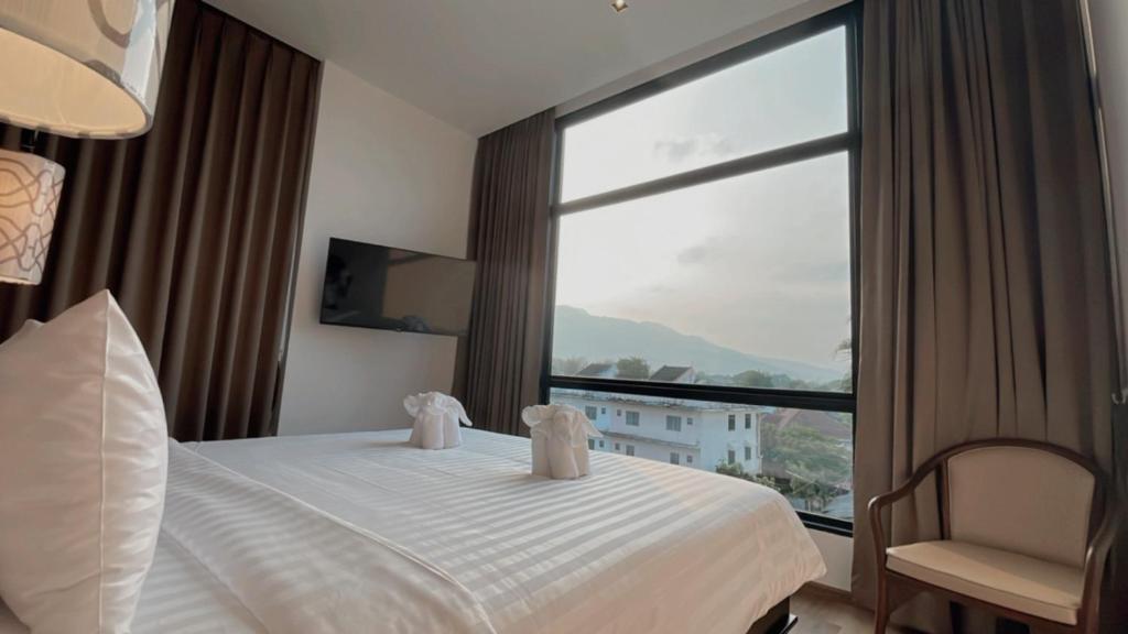 a hotel room with a bed and a large window at Sareeviengping Hotel Chiangmai in Chiang Mai