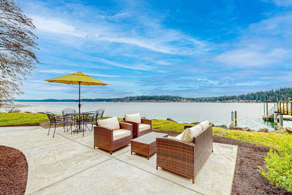 a patio with a table and chairs and an umbrella at The Purple Beach House in Bremerton