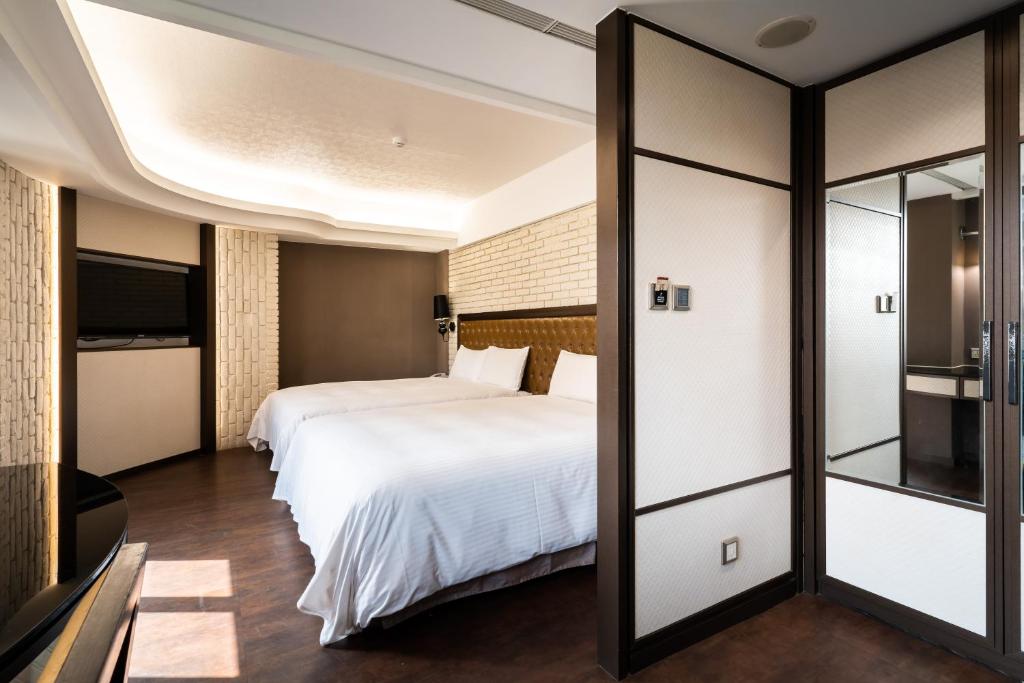 a hotel room with two beds and a tv at The Cloud Hotel in Kaohsiung