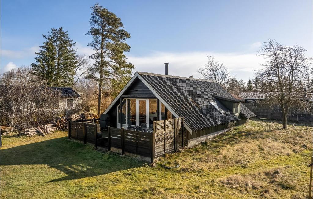 a house with a black roof on a grass field at 2 Bedroom Gorgeous Home In Skjern in Skjern