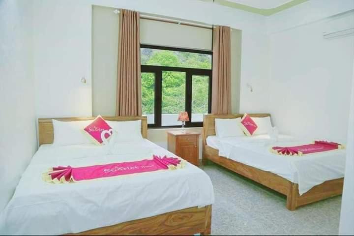 1 dormitorio con 2 camas y ventana en Starlet Hotel Phong Nha en Phong Nha