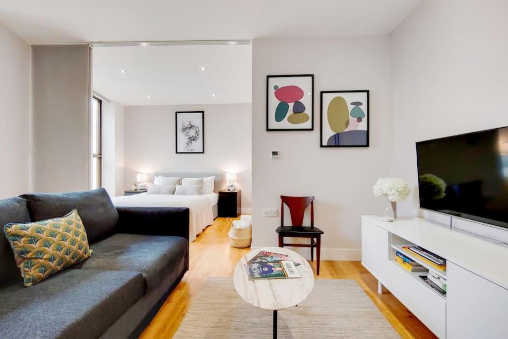 een woonkamer met een bank en een bed bij BR5 - Charming Studio Flat in heart of Borough in Londen