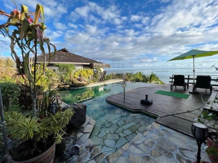 a swimming pool with a deck and a view of the ocean at Tehuarupe Surf Studio 2 in Haapiti