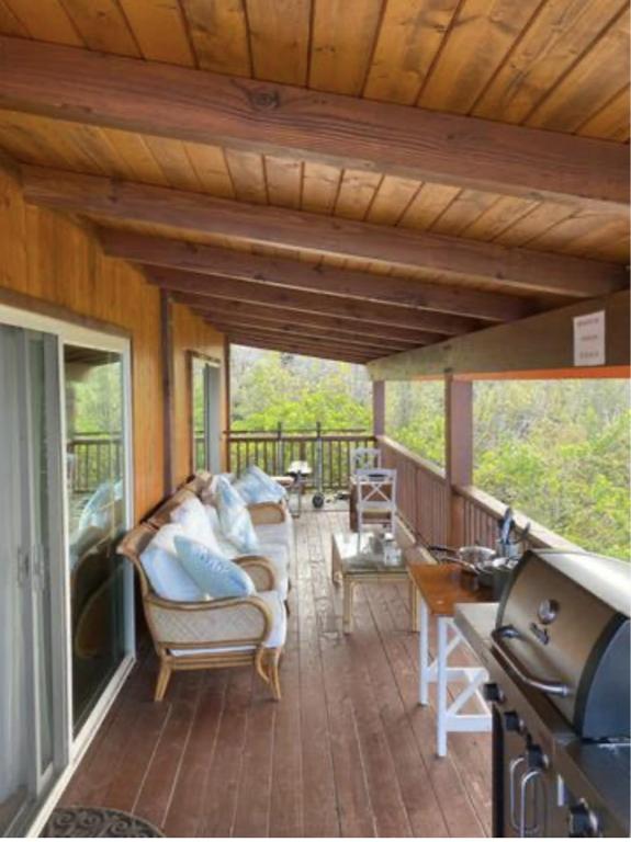 un portico riparato con divano e sedie di Serenity Hale a Papa Bay Estates