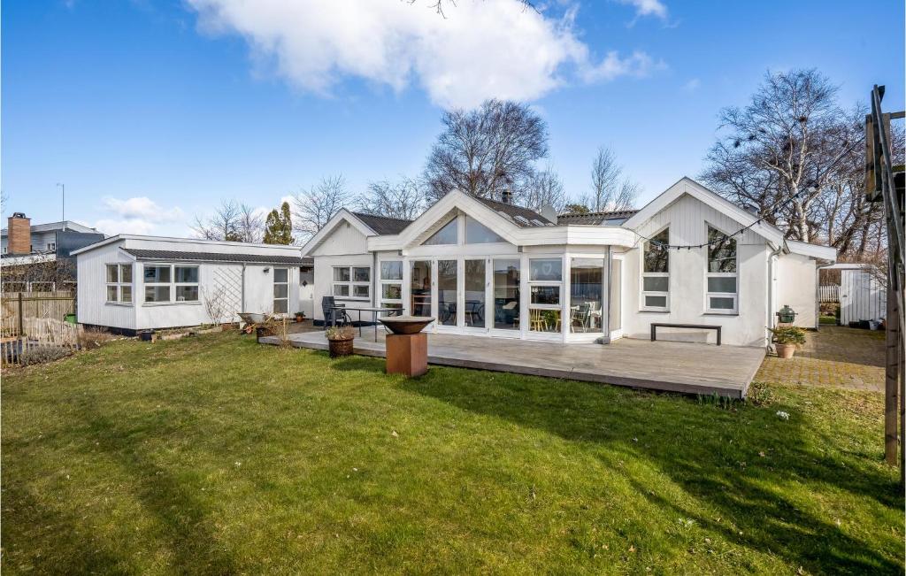 una gran casa blanca con un gran patio trasero en Awesome Home In Kirke Hyllinge With House Sea View, en Kirke-Hyllinge