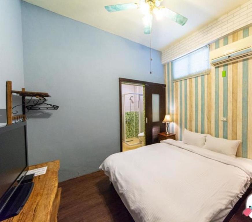 a bedroom with a white bed and a window at Bellalia 貝拉利亞 花蓮民宿 in Hualien City