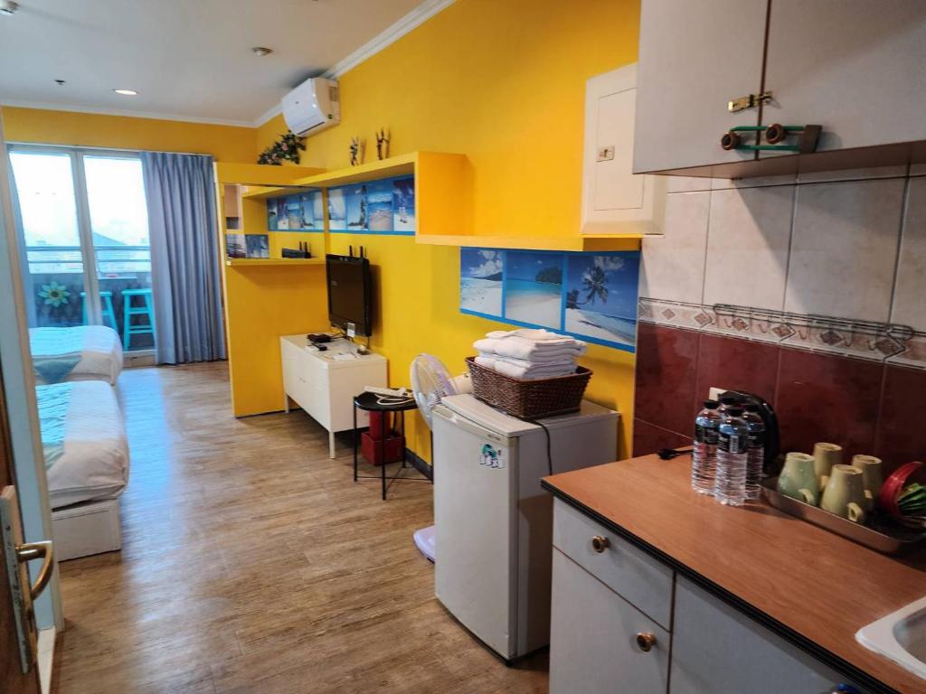 a kitchen with yellow walls and a kitchen with a refrigerator at MB Hotel in Kaohsiung