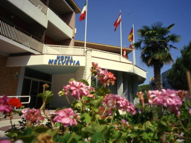 ein Hotel mit Blumen vor einem Gebäude in der Unterkunft Hotel Helvetia in Grado