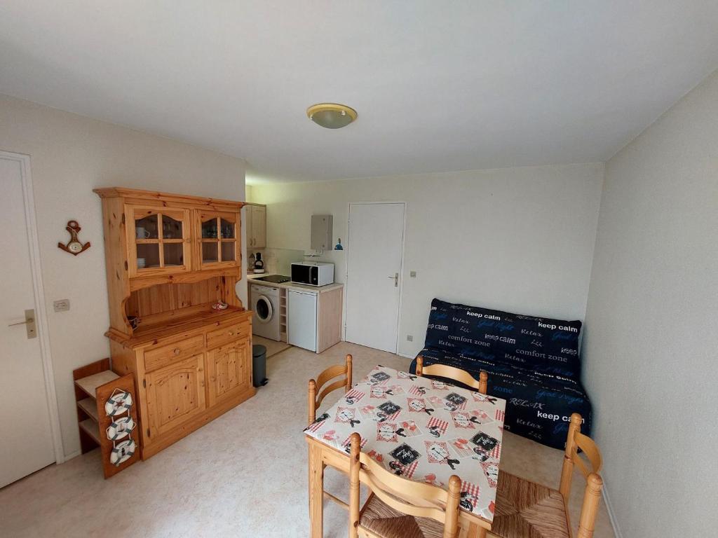 une salle à manger avec une table et une cuisine dans l'établissement Appartement 2 pièces à 300m de la plage avec balcon ensoleillé à Saint-Georges-de-Didonne - FR-1-550-48, à Saint-Georges-de-Didonne
