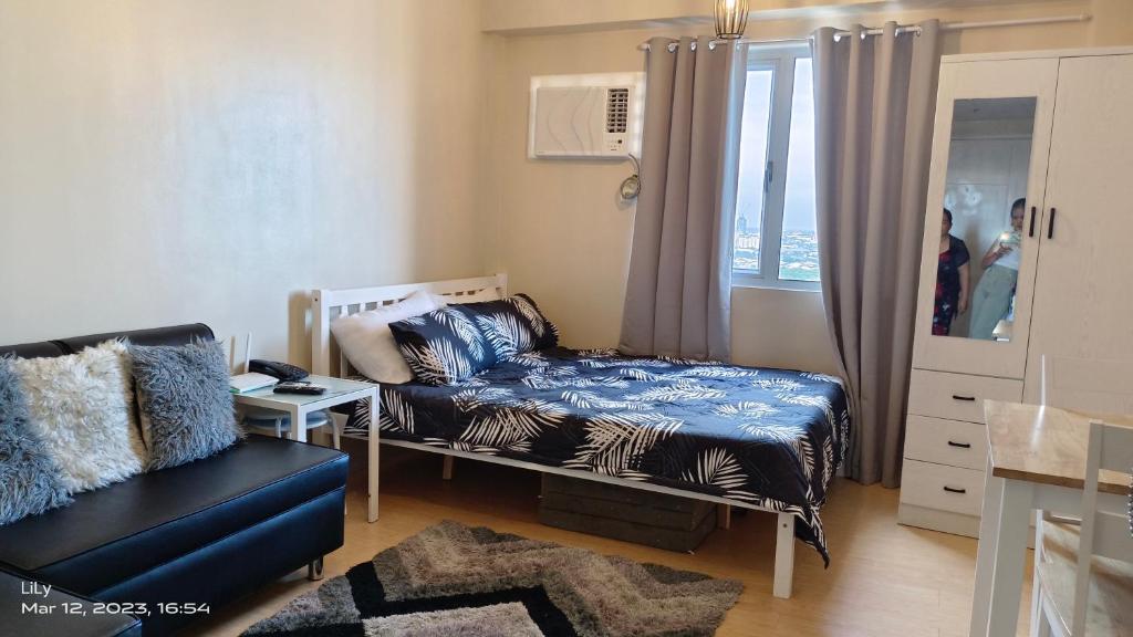 a bedroom with a bed and a chair and a window at SUNVIDA TOWER, across SM City Cebu in Mandaue City