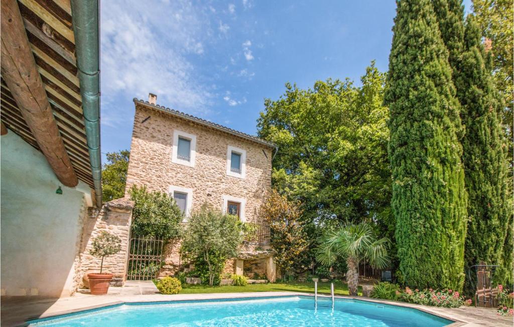 una casa con piscina frente a un edificio en Cozy Home In Oppde With Outdoor Swimming Pool, en Oppède